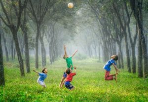 Children expressing joy by playing with a ball