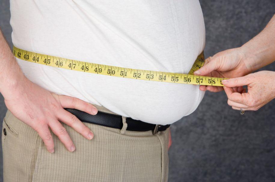 Overweight people have their waists measured.